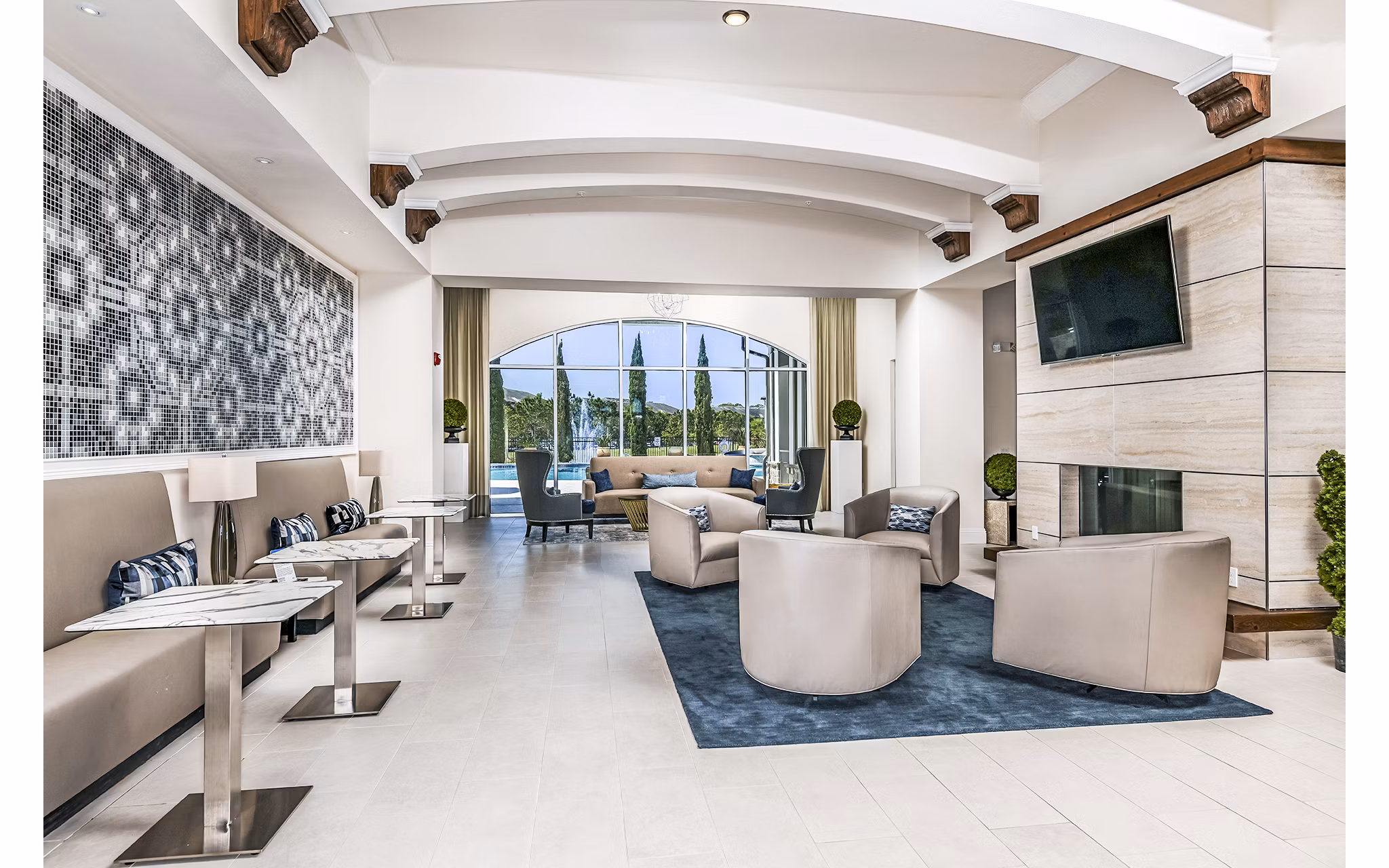 Modern lounge area with stylish seating and a fireplace overlooking a pool