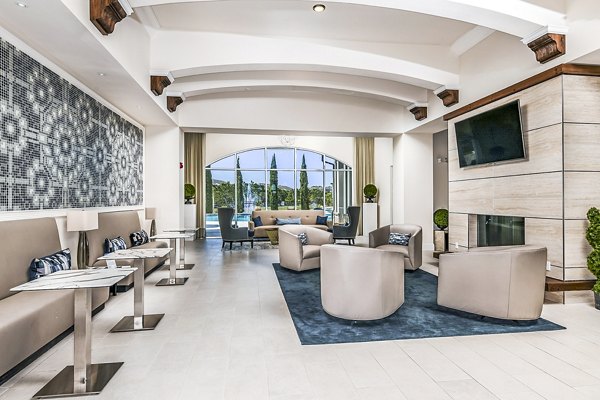 Modern lounge area with stylish seating and a fireplace overlooking a pool