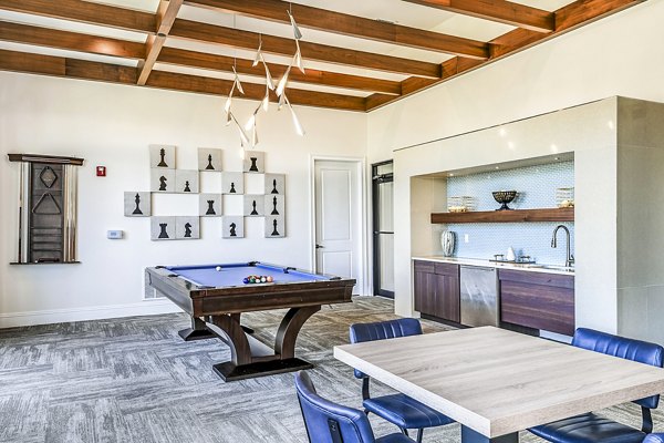 Modern game room with pool table and lounge seating at Venetian Isle Apartments clubhouse