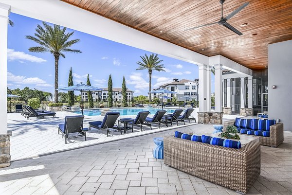 Venetian Isle Apartments: Relaxing pool patio with lounge chairs and palm trees, perfect for outdoor leisure and luxury living