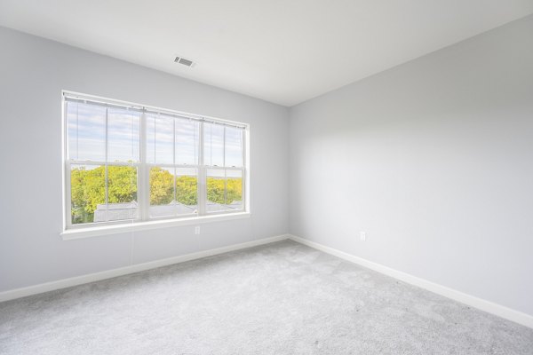 Modern bedroom with chic decor at Arlington 360 Apartments, featuring cozy bedding and ample natural light Perfect for a stylish living experience