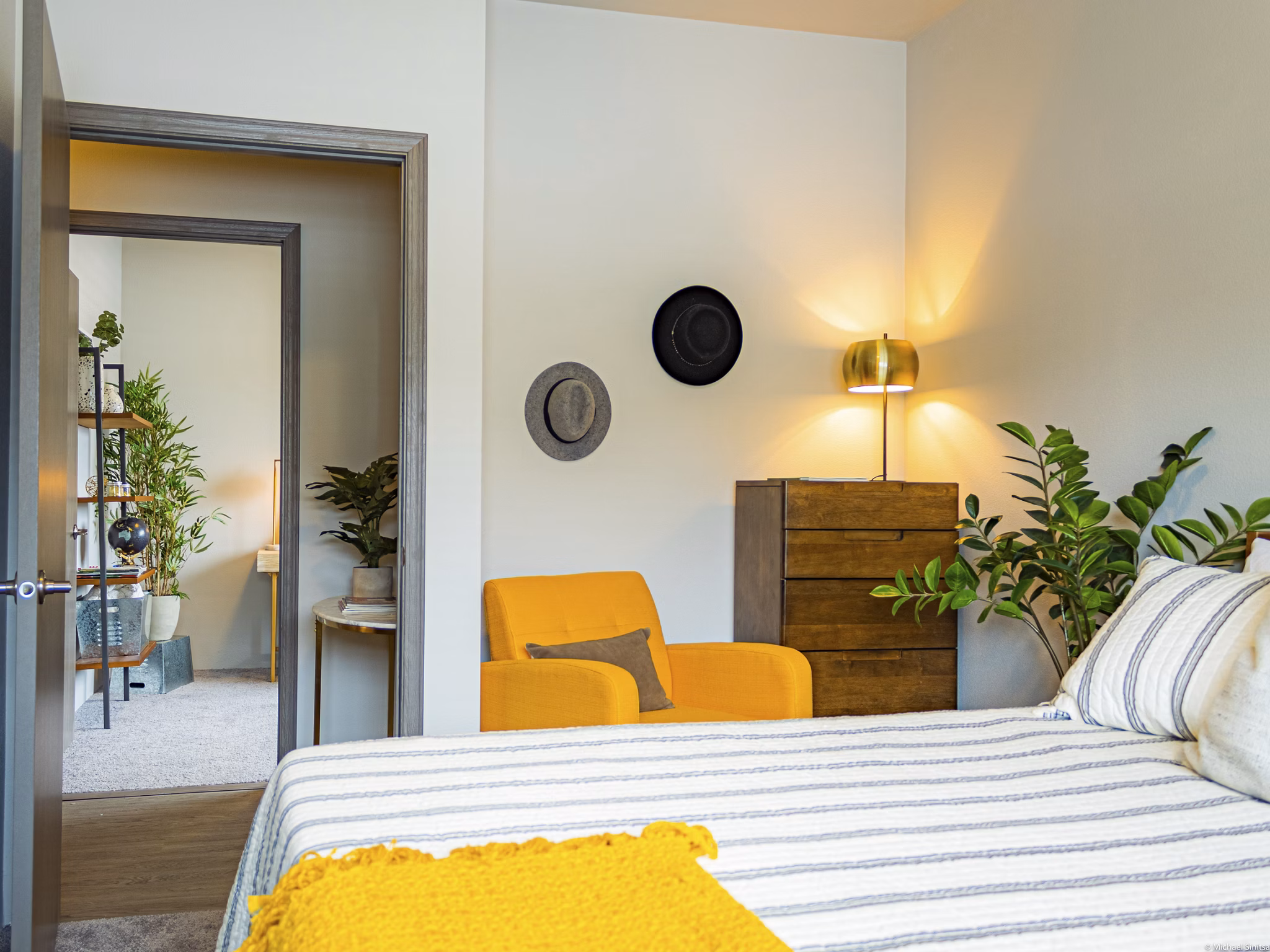 Cozy bedroom with modern decor at Broadway190 Apartments, featuring comfortable bedding and ample natural light