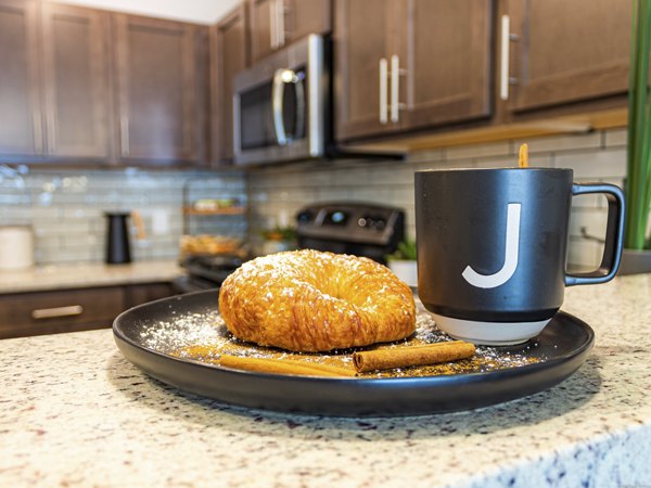 Modern kitchen with stainless steel appliances and granite countertops at Broadway190 Apartments