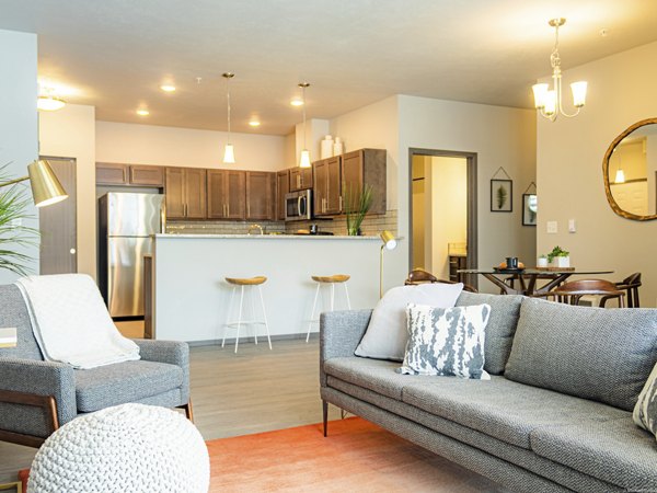 Living room with modern furnishings and large windows in Broadway190 Apartments