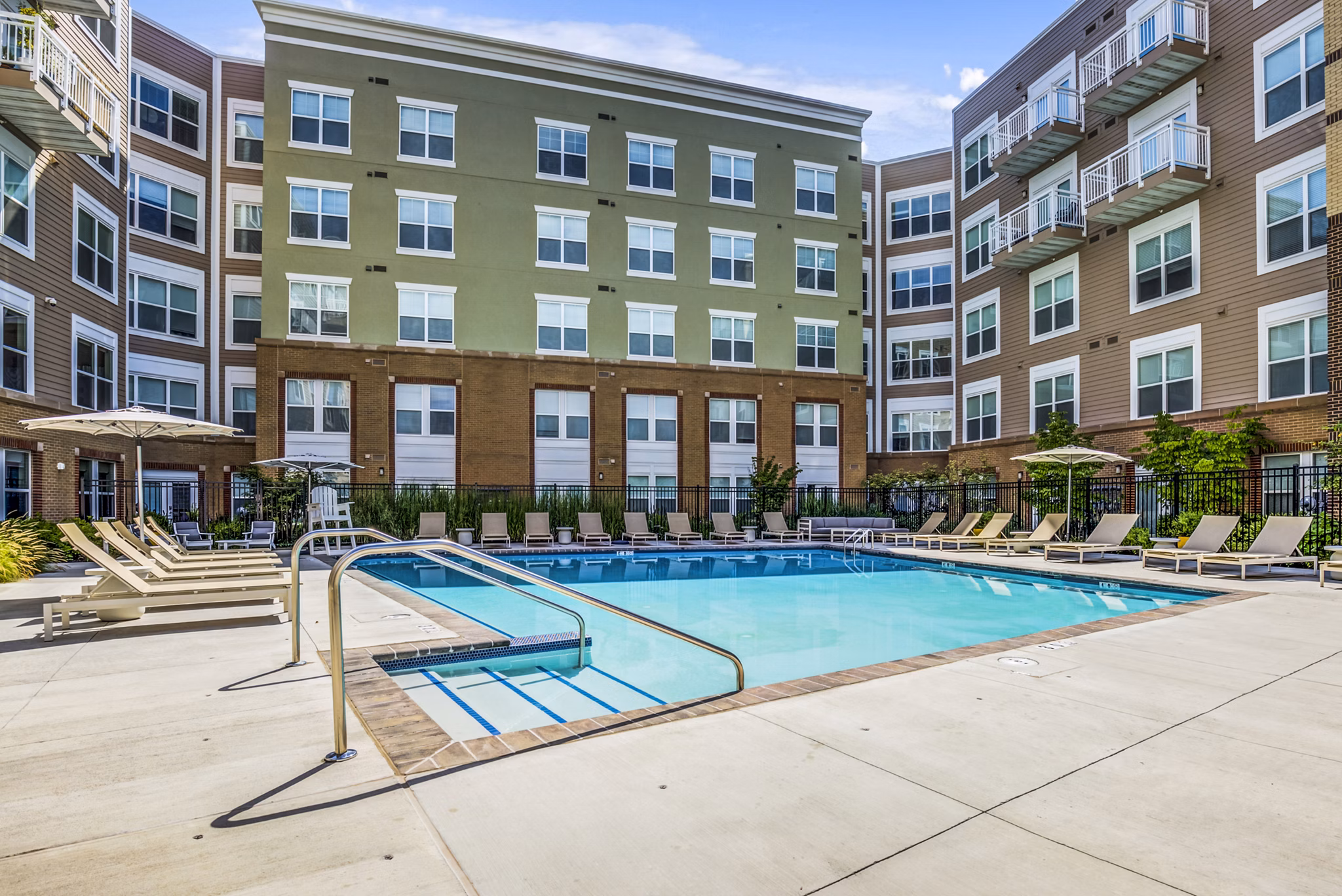 Resort-style pool at The Jameson at Kincora Apartments, surrounded by lush landscaping and modern lounge seating