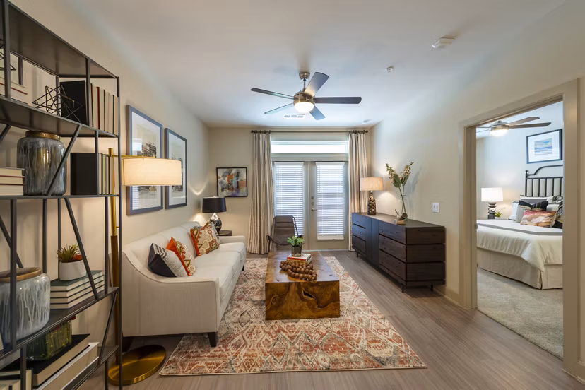 Living room with modern furnishings and large windows at Domain Morgans Landing Apartments