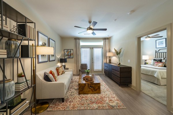Living room with modern furnishings and large windows at Domain Morgans Landing Apartments