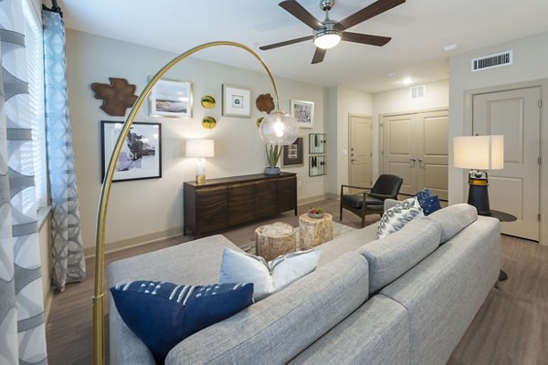 Spacious living room with modern decor and natural light in Domain Morgans Landing Apartments