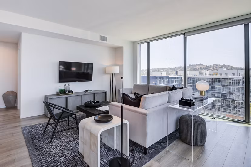 Spacious living room with modern decor and large windows in ARQ Apartments, offering luxury living experience