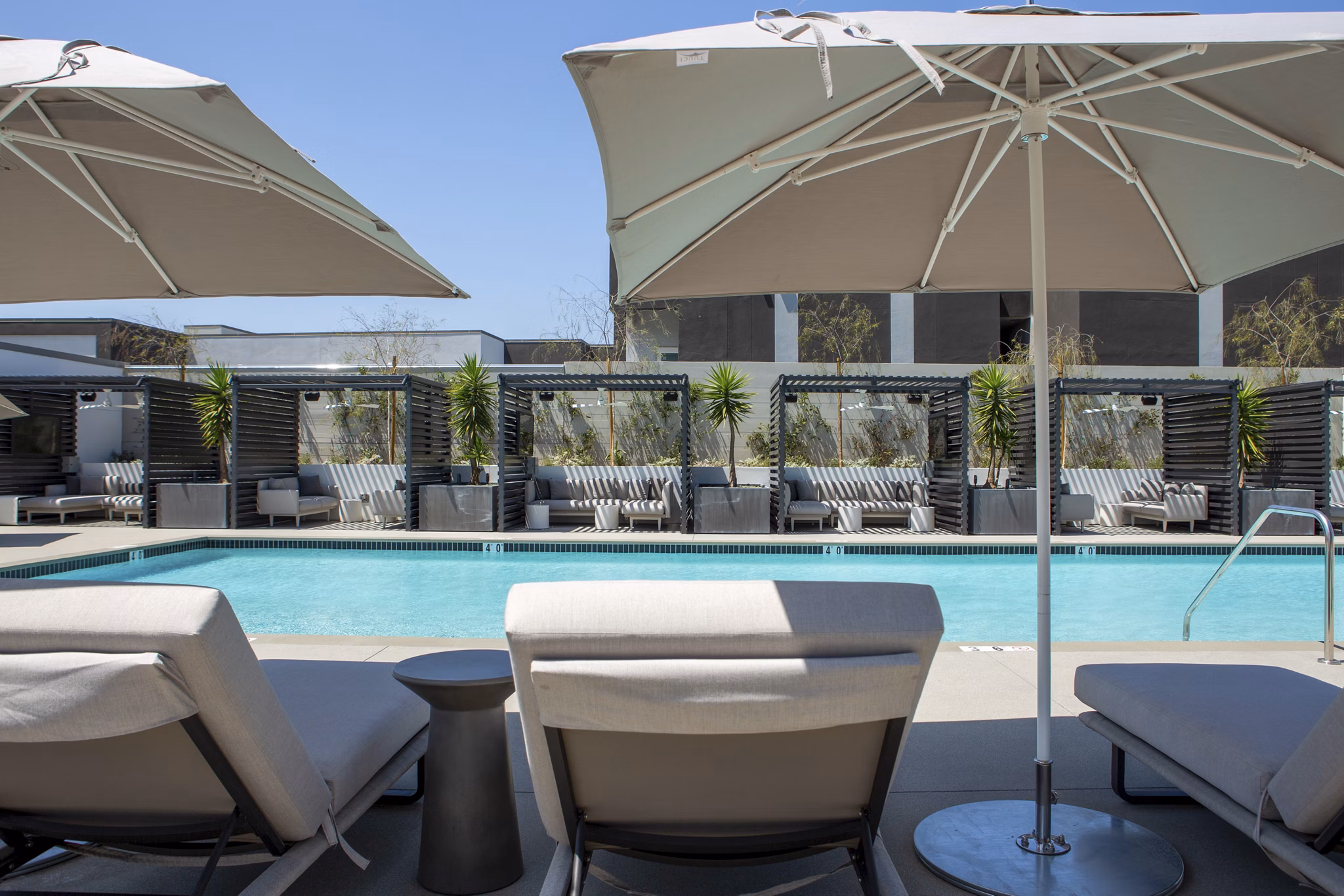 Sunlit rooftop pool at ARQ Apartments offering luxury relaxation area