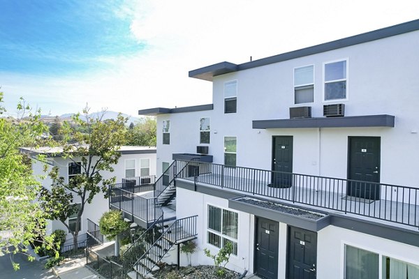 Modern apartment building with multiple levels and balconies in a luxury setting