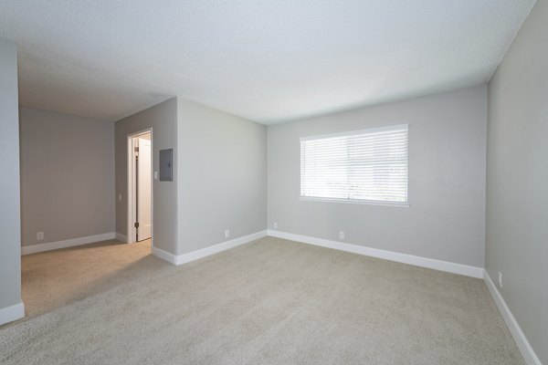 Spacious bedroom with modern decor and natural lighting in Oak & Iron luxury apartments, ideal for comfortable urban living