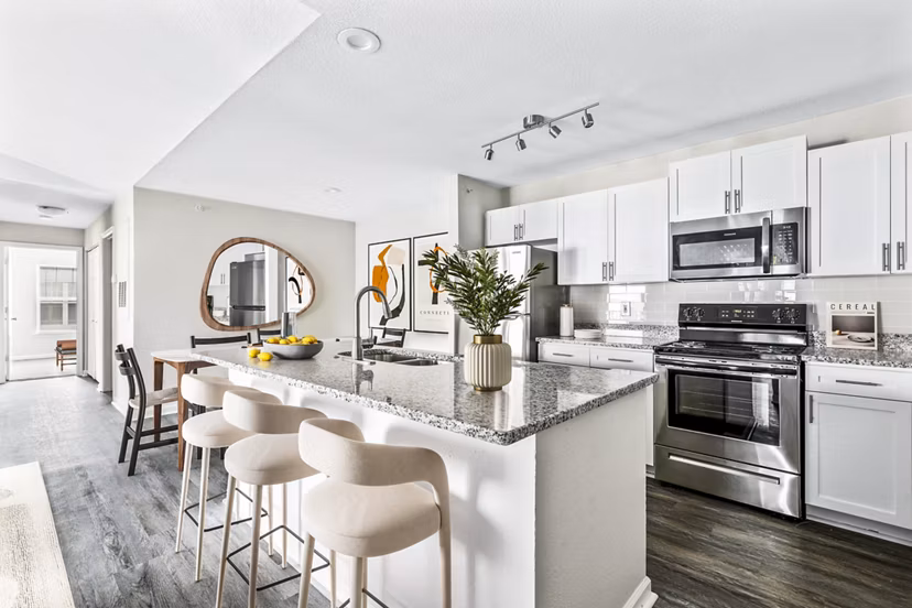 Modern kitchen with stainless steel appliances and granite countertops at Banyan Grove Apartments