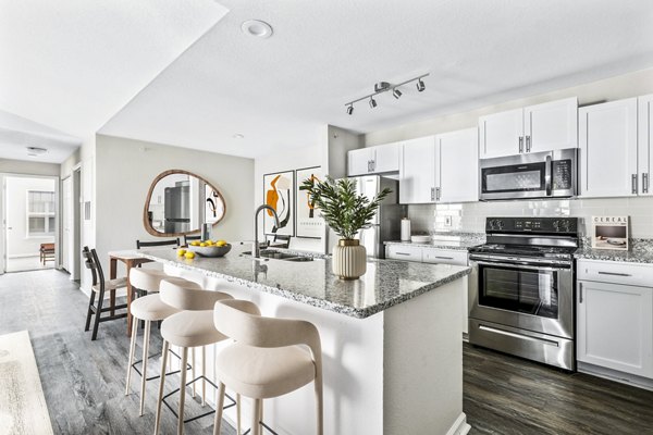 Modern kitchen with stainless steel appliances and granite countertops at Banyan Grove Apartments
