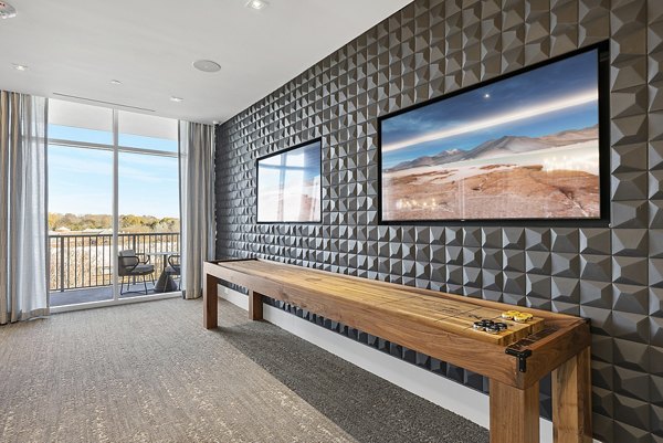 Game room with billiards table and lounge seating at Element SouthPark Apartments