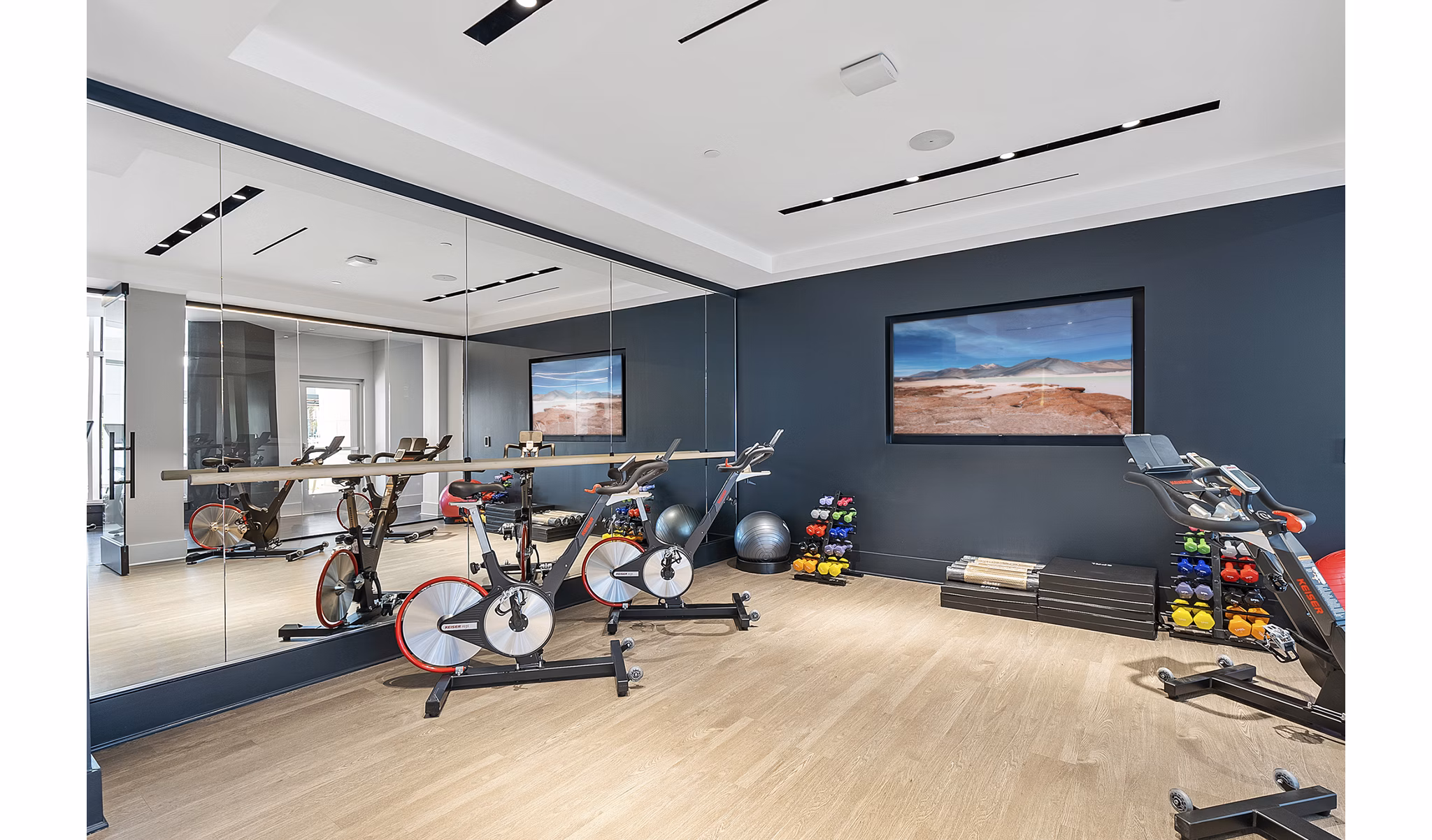 Bright yoga/spin studio with mirrored walls and exercise bikes at Element SouthPark Apartments, Charlotte