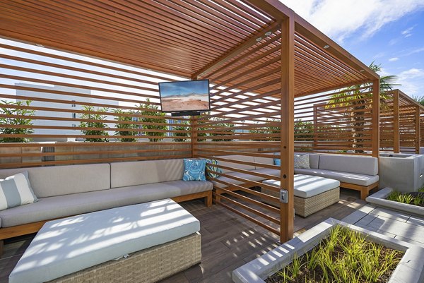 Pool patio with lounge chairs and greenery at Element SouthPark luxury apartments