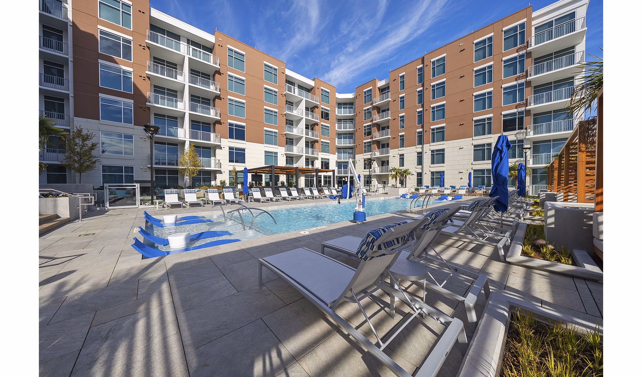 Outdoor swimming pool with lush landscaping at Element SouthPark Apartments, luxury living in Charlotte, offering resort-style amenities