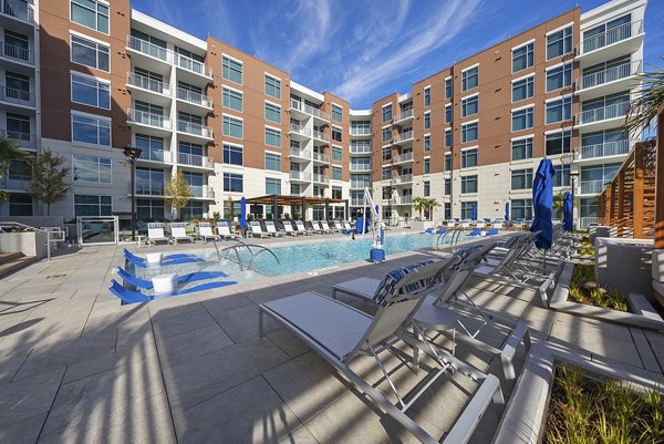 Outdoor swimming pool with lush landscaping at Element SouthPark Apartments, luxury living in Charlotte, offering resort-style amenities