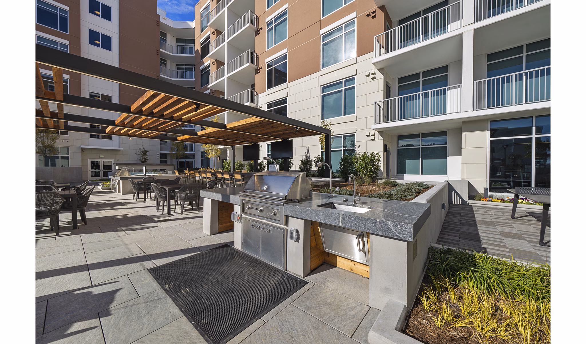 Spacious outdoor grill area with modern seating at Element SouthPark Apartments, ideal for entertaining and relaxation