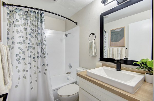 Modern bathroom with dual sinks and marble countertops at Miro Apartments