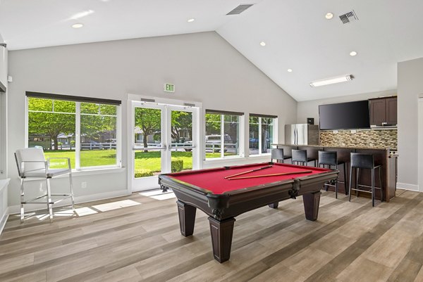 Clubhouse game room featuring pool table and lounge seating at Miro Apartments