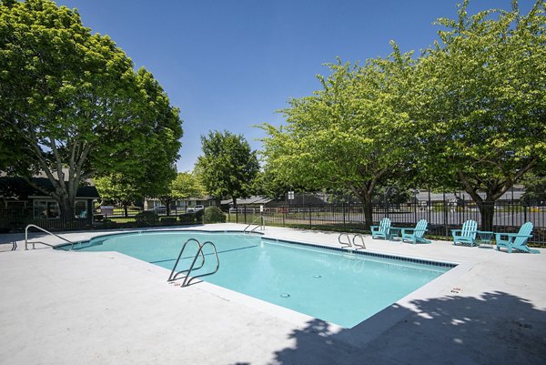 Refreshing outdoor pool at Miro Apartments with sundeck and lounge chairs, perfect for relaxation and recreation in a luxury setting
