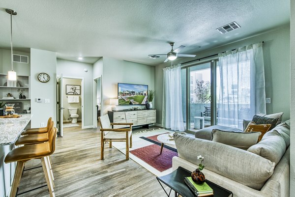 Living room with modern decor and ample natural light at Amiya Apartments, luxury residential complex