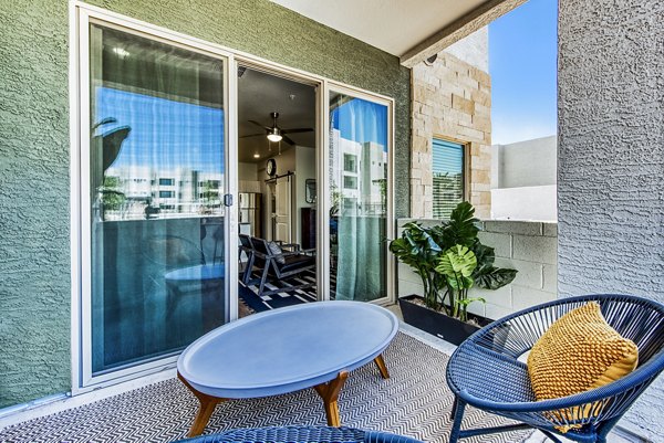 Patio with cozy seating and potted plants at Amiya Apartments