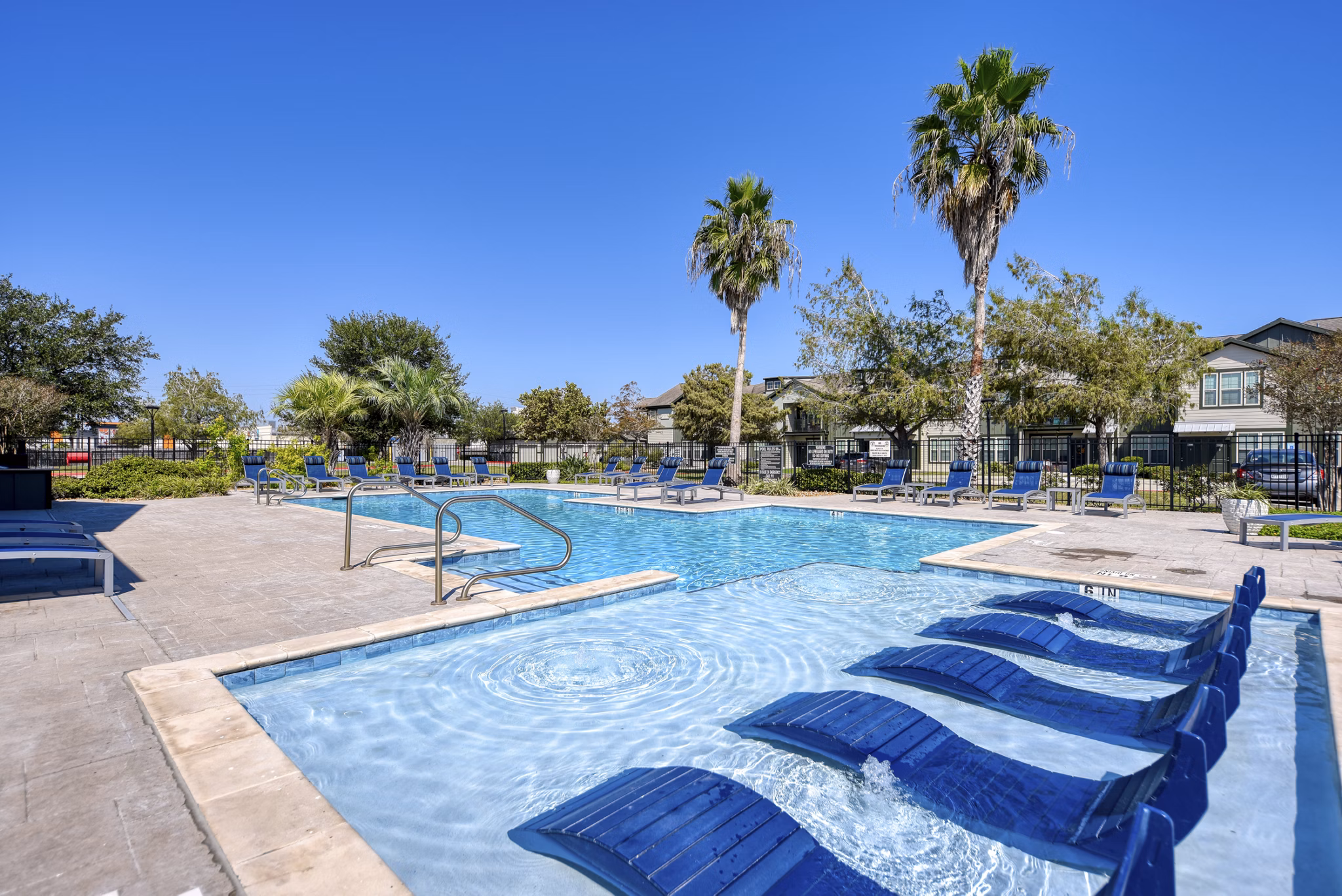 Chic poolside oasis at Sage Apartments offering luxury relaxation and sunbathing areas