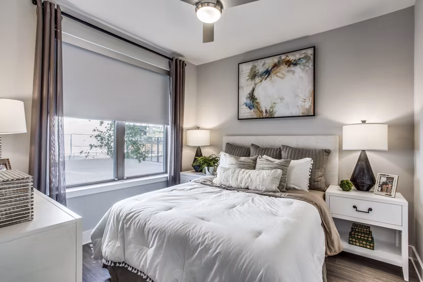 Bedroom with large windows and modern decor at Trailhead Apartments