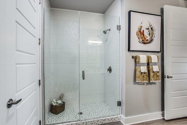 Modern bathroom featuring glass-enclosed shower at Trailhead Apartments, luxury living by Greystar