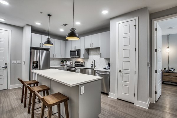 Luxe kitchen with modern appliances at Trailhead Apartments, featuring sleek cabinetry and granite countertops