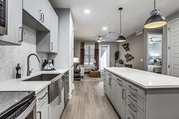 Modern kitchen with stainless steel appliances and granite countertops at Trailhead Apartments