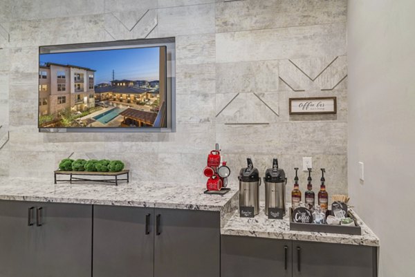 Clubhouse kitchen area featuring modern appliances and island seating at Album Keller Ranch Apartments