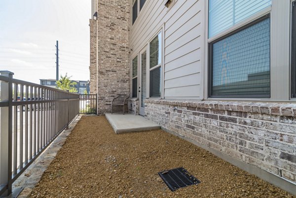 Charming patio yard with lush greenery at Album Keller Ranch Apartments, perfect for outdoor relaxation and entertaining