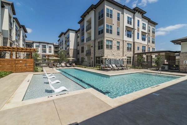Relaxing pool area with lounge seating at Album Keller Ranch Apartments, perfect for outdoor enjoyment and leisure activities
