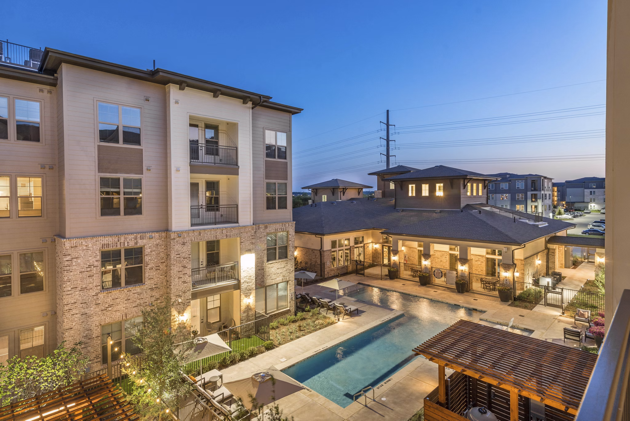 Resort-style pool area at Album Keller Ranch Apartments featuring lounge chairs and landscaped surroundings