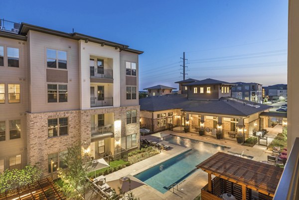Resort-style pool area at Album Keller Ranch Apartments featuring lounge chairs and landscaped surroundings