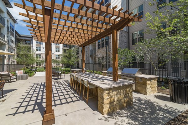 Outdoor grill area with seating at Album Keller Ranch Apartments