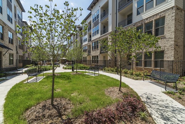 Album Keller Ranch: Outdoor grill area with seating and shade at luxury apartments in a serene community setting