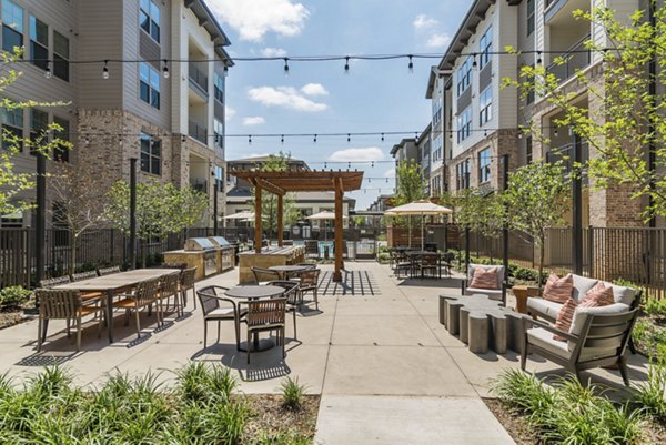 Outdoor grill area with modern seating at Album Keller Ranch Apartments