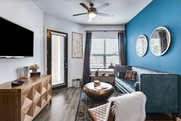 Spacious living room with modern decor and large windows in Mezzo Kirby Med Center Apartments