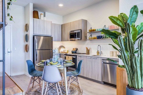 Modern kitchen/dining room with sleek cabinetry and stainless steel appliances at Ryder Apartments
