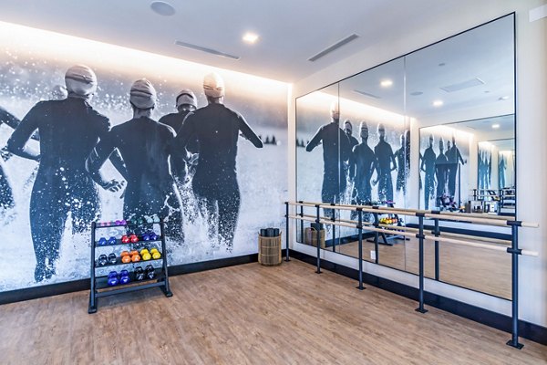 Yoga studio with wooden flooring and natural light at Ryder Apartments, luxurious fitness amenities promoting wellness and relaxation
