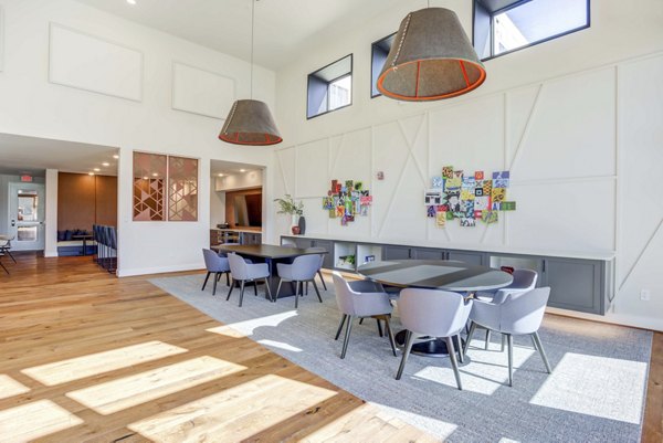 Clubhouse with modern amenities at Alder Apartments: Luxury social space for residents featuring comfortable seating and a grand fireplace