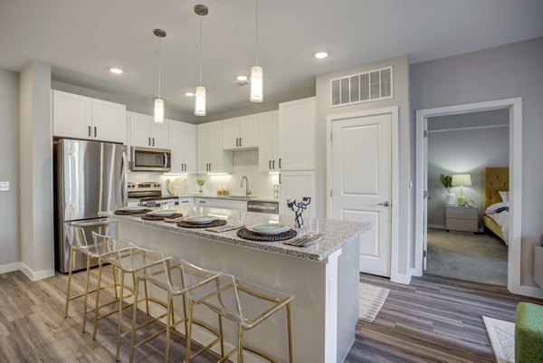 Modern kitchen with stainless steel appliances in Alder Apartments, featuring a sleek design and ample counter space