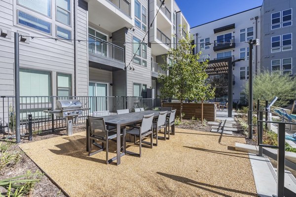 Outdoor BBQ grill area with modern seating at Alder Apartments