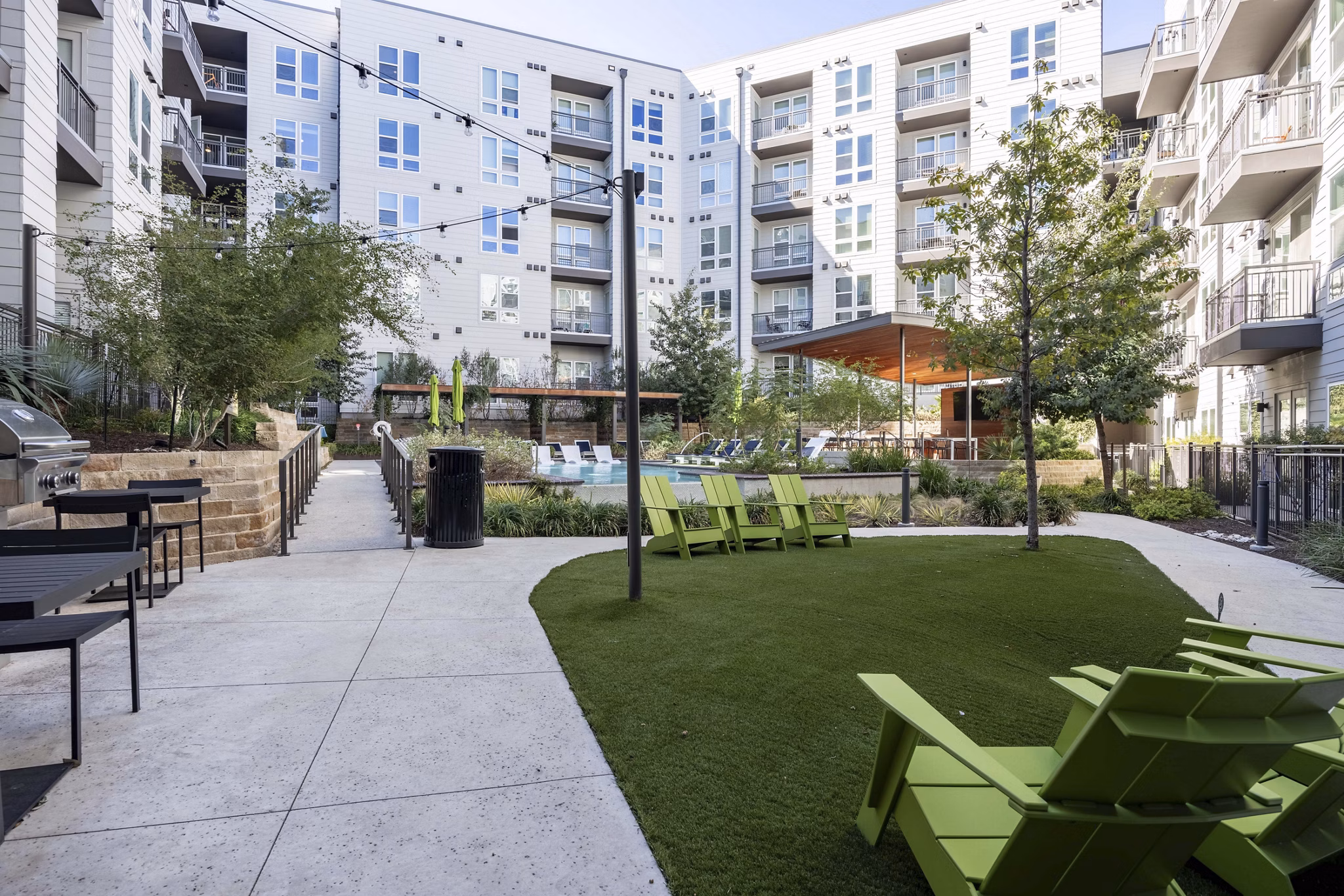 Outdoor courtyard featuring lush landscaping and seating areas at Alder Apartments