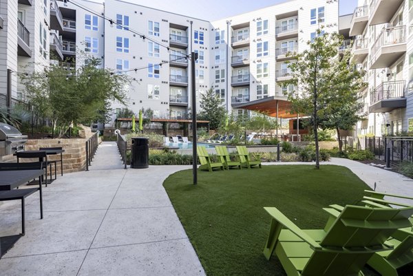 Outdoor courtyard featuring lush landscaping and seating areas at Alder Apartments